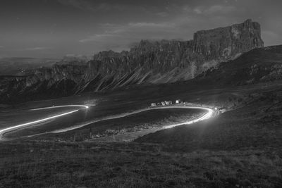 Light trails on road against sky at night