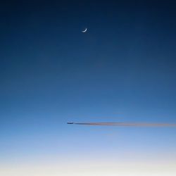 Low angle view of vapor trail against clear blue sky