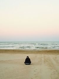 Rear view of man sitting on beach