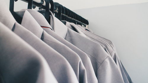 Close-up of full suits arranged in closet