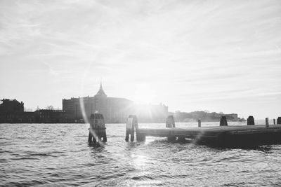 Group of people walking on river against buildings