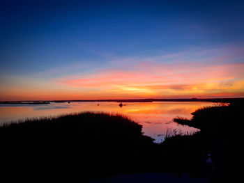 Scenic view of lake against romantic sky at sunset