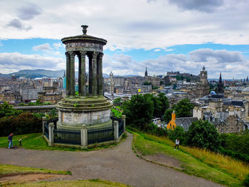 View of cityscape against cloudy sky