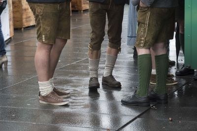 Low section of people standing on tiled floor