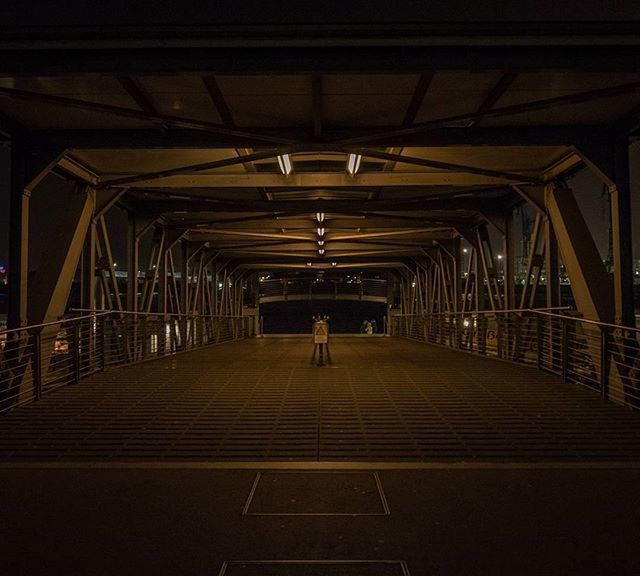 indoors, the way forward, ceiling, built structure, transportation, architecture, diminishing perspective, railing, vanishing point, illuminated, subway, empty, incidental people, architectural column, connection, railroad station, full length, railroad station platform, long