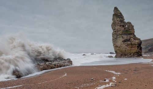 Scenic view of rocks on beach against sky