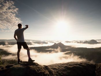 Man at the top of a mountain looking the misty landscape around. feel free