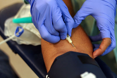 Cropped image of doctor preparing patient for blood donation