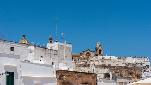 Low angle view of buildings against clear blue sky