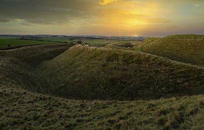 Scenic view of land against sky during sunset