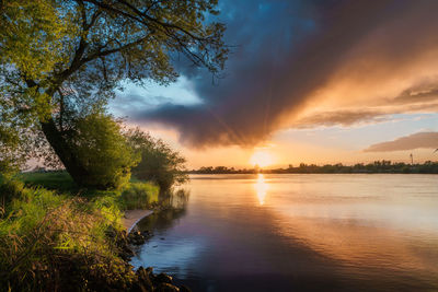 Sunset over the river weser in northern germany with dramatic rain clouds in the sky