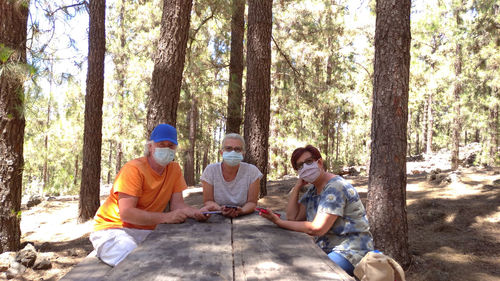 Rear view of people sitting in the forest