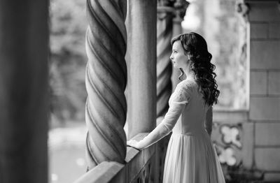 Side view of woman standing against wall