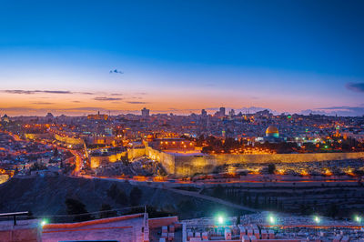 High angle view of illuminated city against sky at sunset