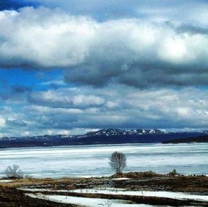 Scenic view of lake against cloudy sky