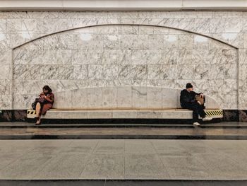 Side view of a couple sitting on road in city