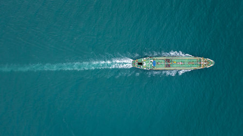 Aerial top view oil ship tanker sailing full speed with beautiful wave and splash water in line 