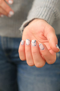 Manicured female hands with stylish blue nails and minimalistic design. trendy modern design manicur