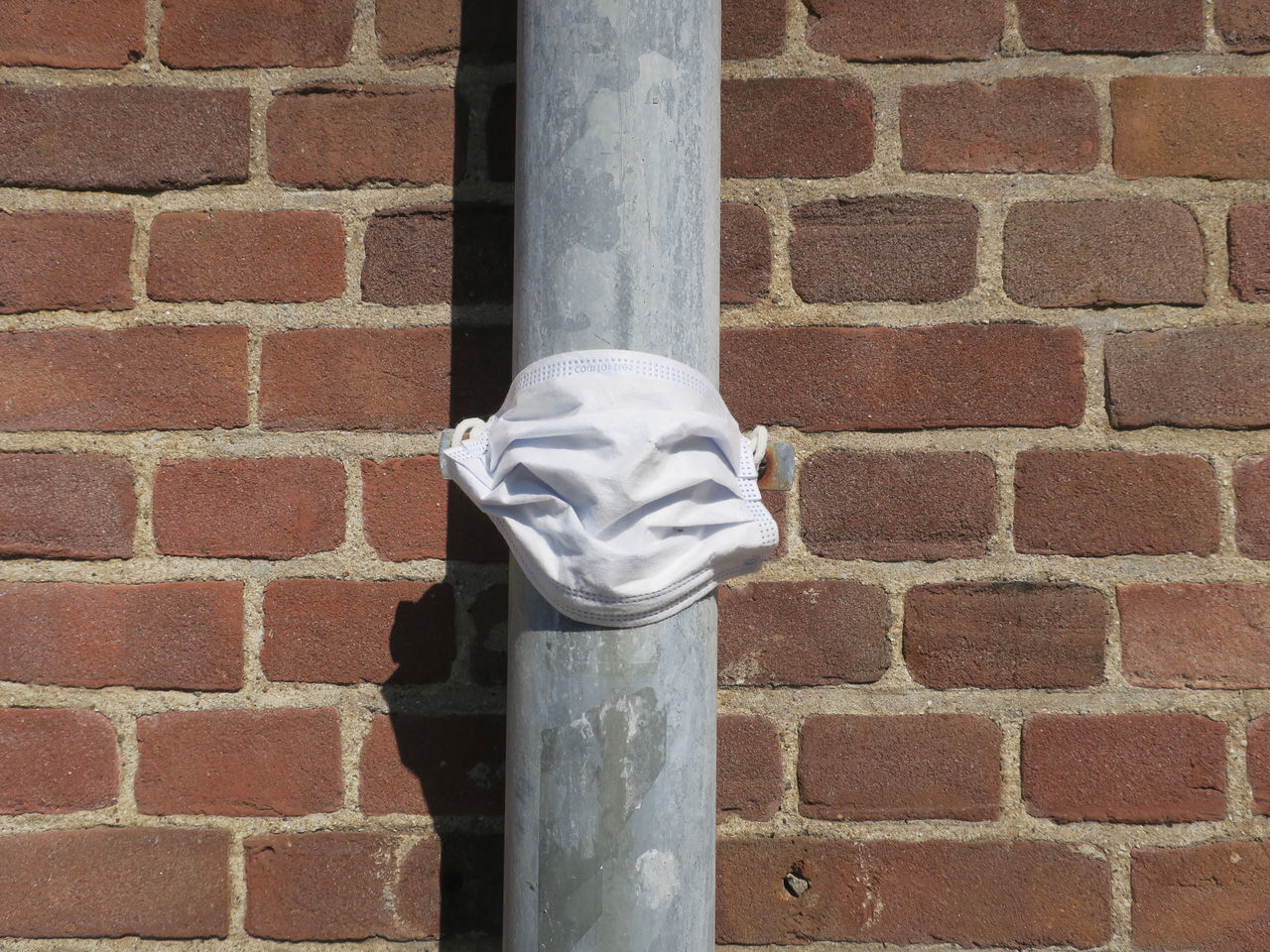 CLOSE-UP OF DOOR KNOCKER ON BRICK WALL BY STONE BUILDING