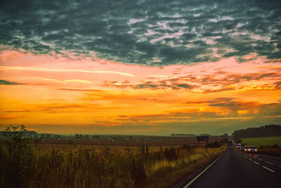 Road amidst landscape against sky during sunset