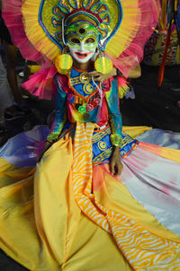 Full length of woman standing on multi colored umbrella