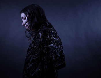 Side view of woman looking away against gray background