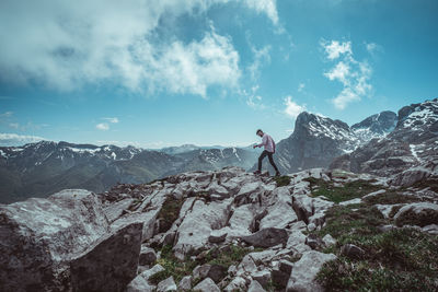 Man standing on rock against sky