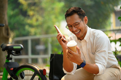 Side view of young man using mobile phone