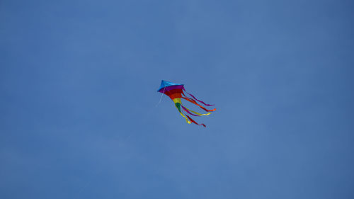 Low angle view of flag against clear blue sky