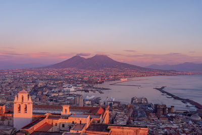 Naples during a pinky sunset, in the backgroung vesuvius