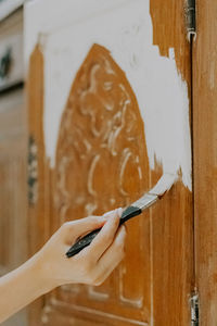 A young girl is painting an old closet.