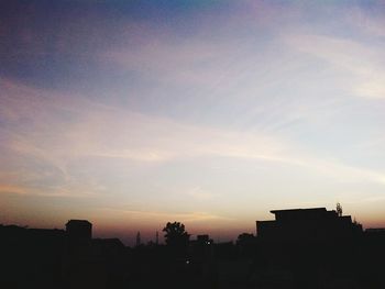 Silhouette city against sky during sunset