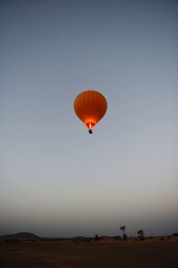 Hot air balloon against clear sky during sunset