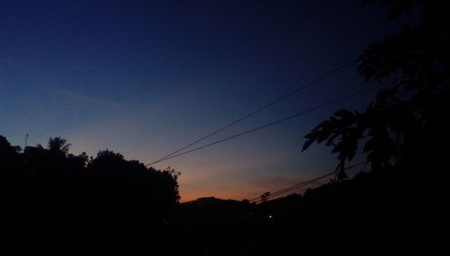 Low angle view of silhouette trees against clear sky