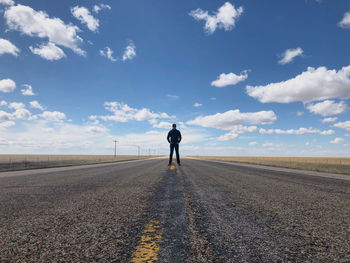 Front view of man standing on road against sky