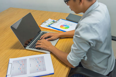 Midsection of man working on table