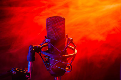 Close-up of microphone against orange sky