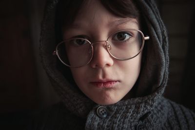 Close-up portrait of boy wearing warm clothing and eyeglasses