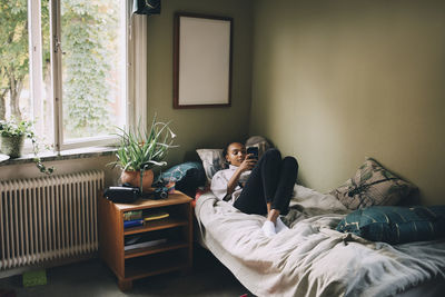 Young woman lying on bed at home