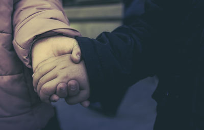 Close-up of mother holding baby hand