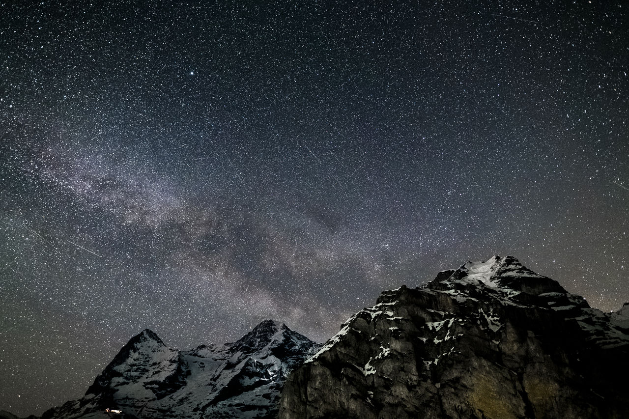 LOW ANGLE VIEW OF SNOWCAPPED MOUNTAIN AGAINST STAR FIELD AT NIGHT