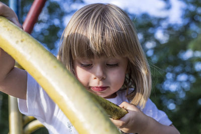 Close-up of cute girl holding plant in yard