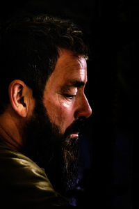 Portrait of young man against black background
