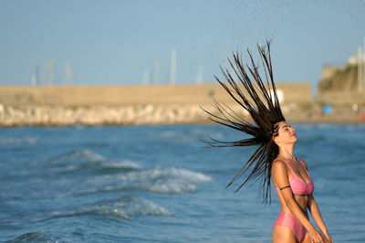 Woman standing in water against sky