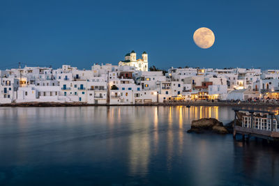 Scenic view of sea and buildings against clear sky