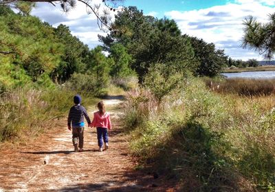 Rear view of woman walking on footpath