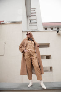  female fashion model, posing for a full length photo, wearing total beige outfit, street fashion