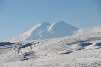 Scenic view of snowcapped mountains against clear blue sky