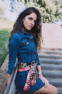 Portrait of young woman standing against trees