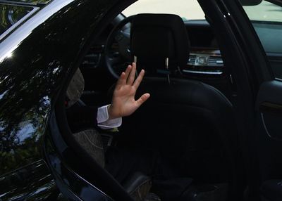 Cropped image of person waving hand in car